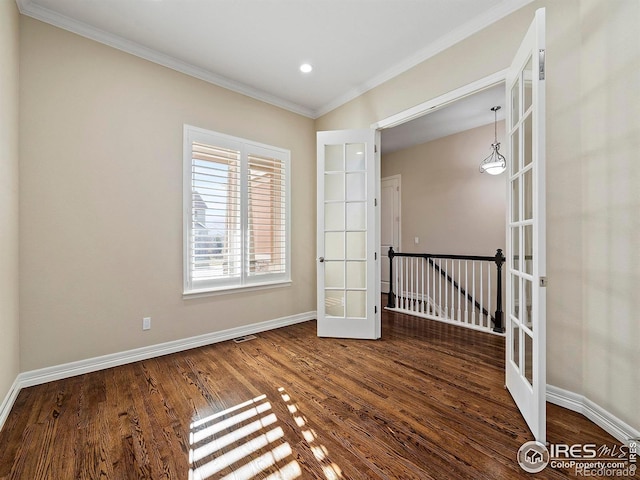 spare room featuring dark hardwood / wood-style flooring, ornamental molding, and french doors