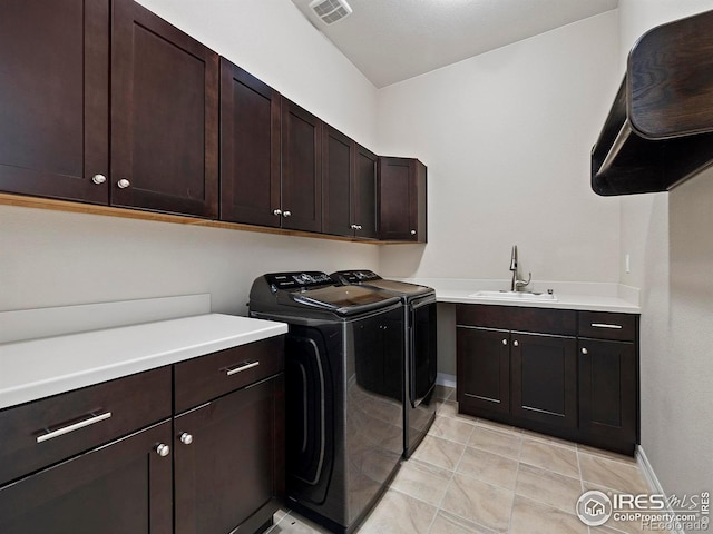 laundry room featuring washer and dryer, cabinets, light tile patterned floors, and sink