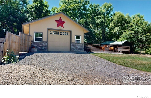 view of front of property featuring a garage and an outbuilding