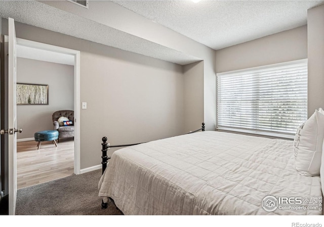 bedroom featuring hardwood / wood-style floors and a textured ceiling