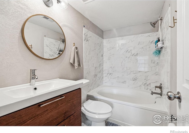 full bathroom featuring vanity, tiled shower / bath combo, and toilet