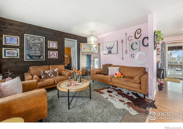 living room with hardwood / wood-style floors, plenty of natural light, and wooden walls