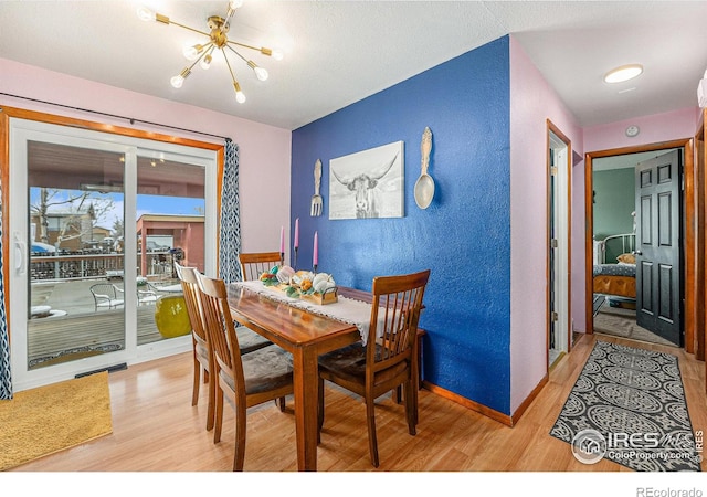 dining area featuring light hardwood / wood-style floors and a chandelier