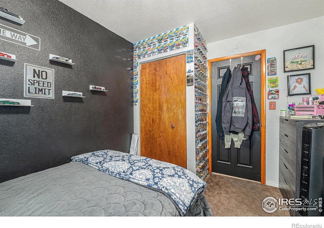 bedroom with carpet flooring, a textured ceiling, and a closet