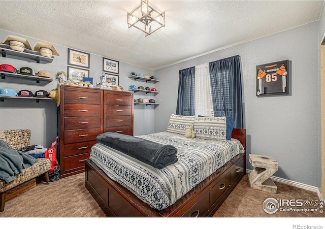 carpeted bedroom featuring a textured ceiling and an inviting chandelier