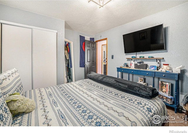 bedroom with a textured ceiling and a closet