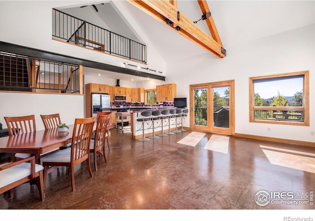 dining room featuring beam ceiling and high vaulted ceiling