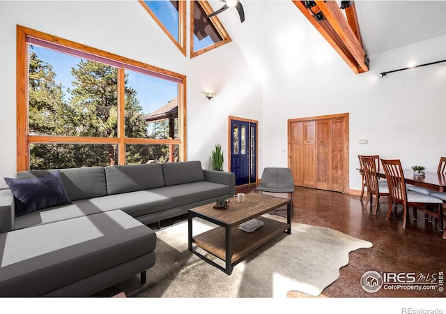 living room with beamed ceiling and high vaulted ceiling