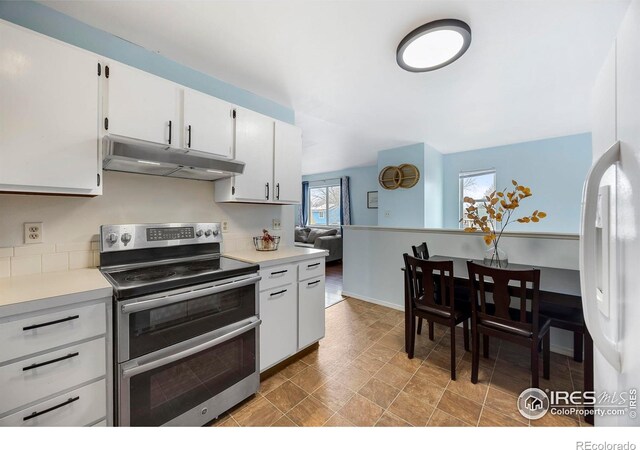 kitchen featuring white cabinetry, stainless steel electric range oven, and white fridge with ice dispenser