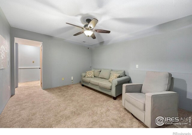 carpeted living room featuring ceiling fan