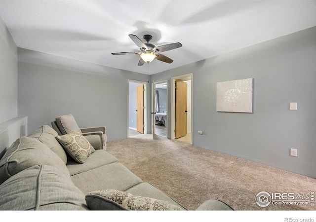 carpeted living room with ceiling fan