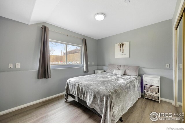 bedroom featuring lofted ceiling and wood-type flooring