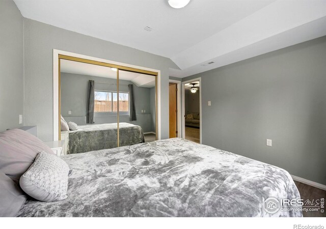 bedroom featuring wood-type flooring, a closet, and lofted ceiling