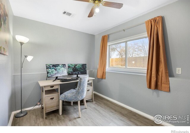 office with light wood-type flooring and ceiling fan