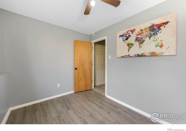 spare room with ceiling fan and wood-type flooring