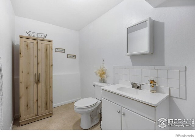 bathroom featuring tasteful backsplash, tile patterned flooring, vanity, and toilet