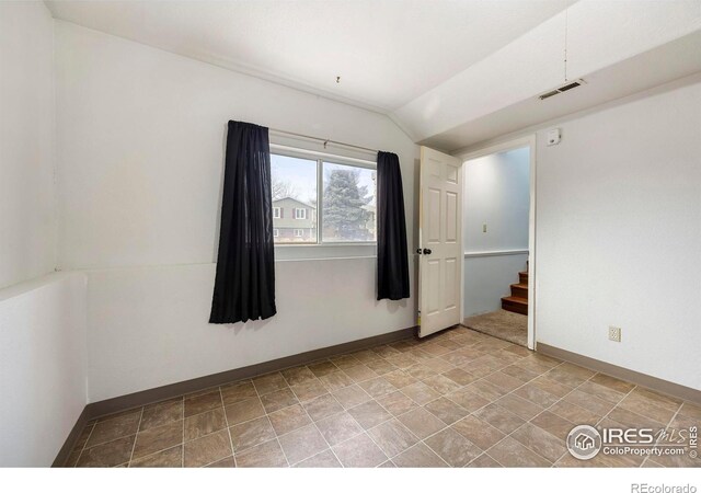 empty room featuring vaulted ceiling