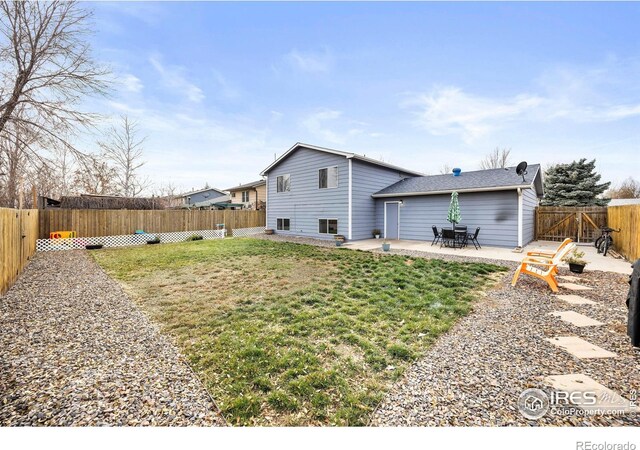 rear view of property with a yard and a patio