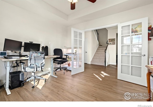 office area featuring a raised ceiling, wood-type flooring, ceiling fan, and french doors