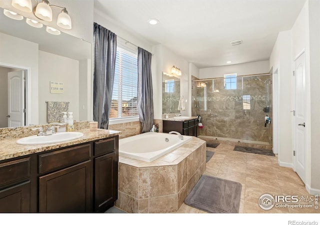 bathroom with vanity and separate shower and tub