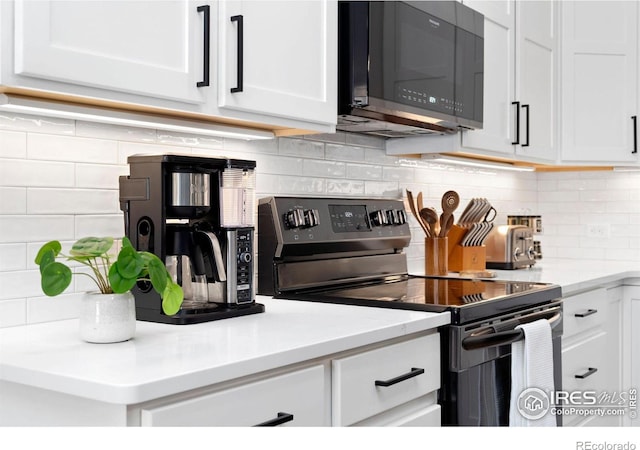 kitchen featuring white cabinets, stainless steel electric range oven, and tasteful backsplash