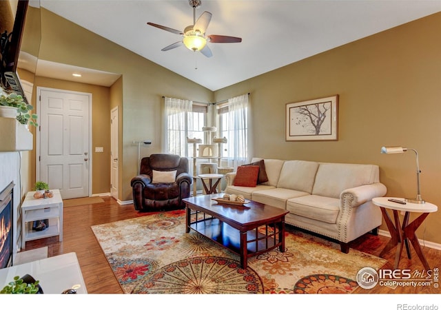 living room with ceiling fan, wood-type flooring, and vaulted ceiling