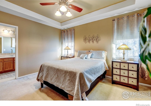 bedroom featuring multiple windows, ensuite bathroom, ceiling fan, and light carpet