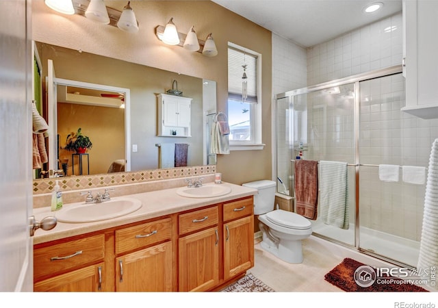 bathroom featuring vanity, toilet, and a shower with shower door