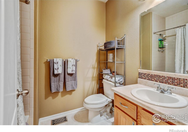 bathroom featuring toilet, vanity, tasteful backsplash, and tile patterned floors