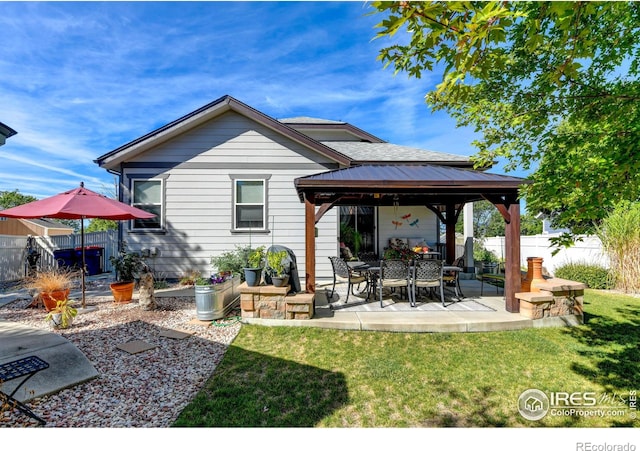 rear view of property featuring a gazebo, a patio area, and a lawn