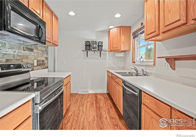 kitchen with backsplash, stainless steel appliances, light hardwood / wood-style flooring, and sink