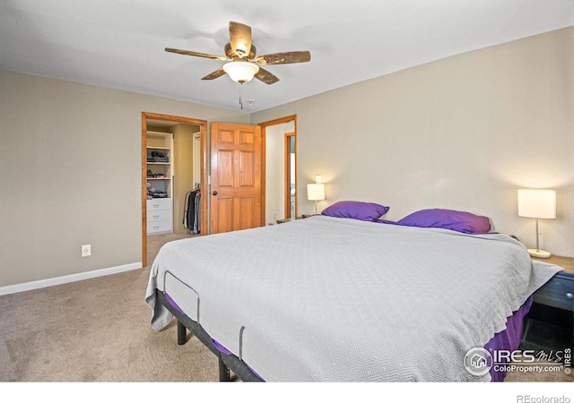 carpeted bedroom featuring ceiling fan and a spacious closet