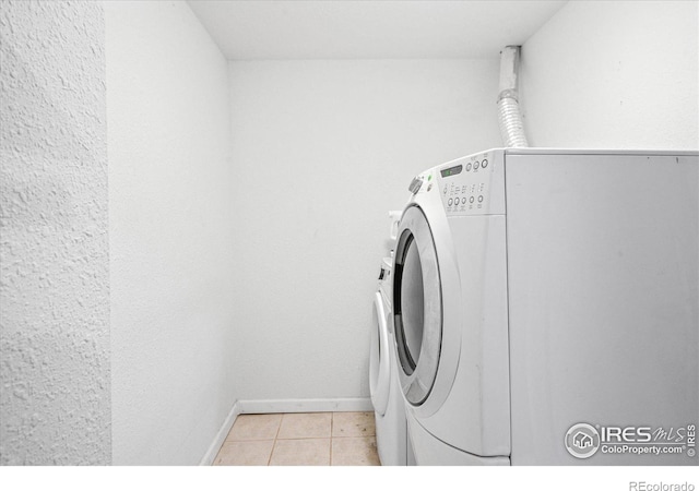 laundry area featuring light tile patterned floors and washing machine and clothes dryer