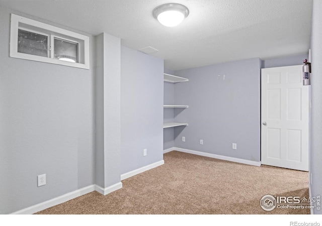 basement featuring a textured ceiling and carpet floors