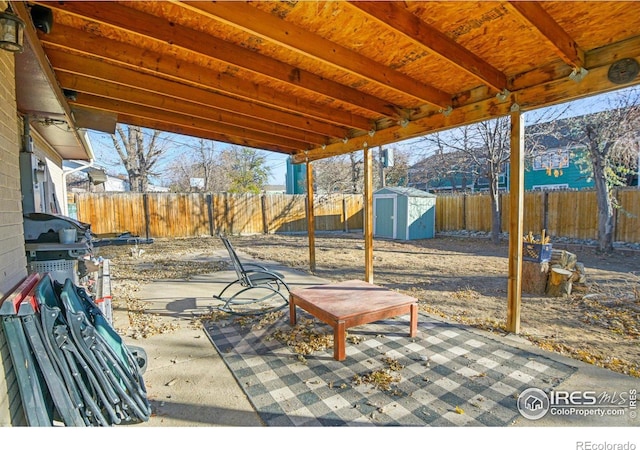 view of patio with a storage shed and a water view