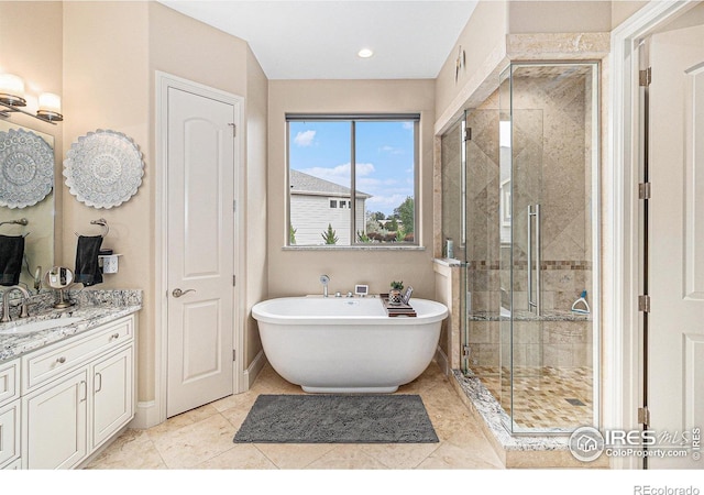 bathroom with vanity, tile patterned flooring, and plus walk in shower