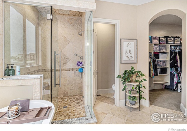 bathroom with tile patterned floors, toilet, and a shower with shower door