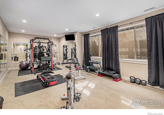 workout room featuring light carpet