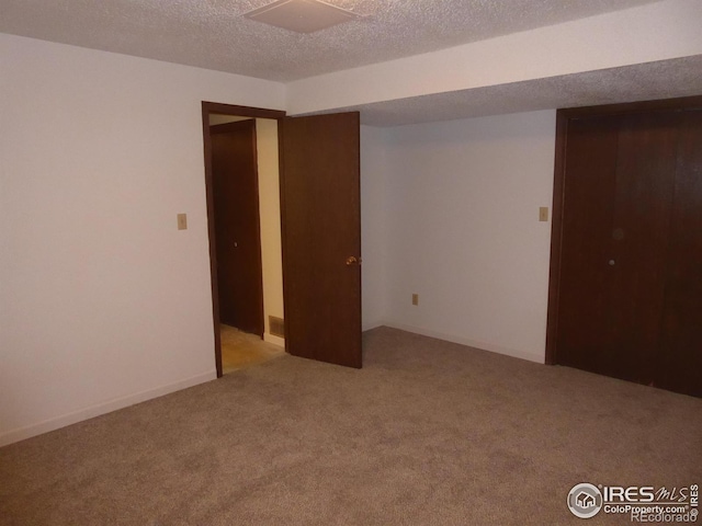 carpeted spare room featuring a textured ceiling