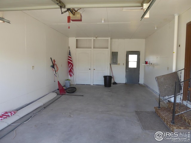 garage with a garage door opener and electric panel