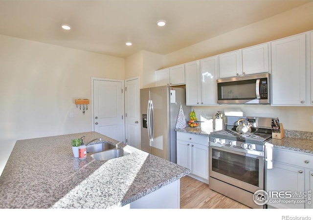 kitchen with white cabinetry, sink, light hardwood / wood-style flooring, and appliances with stainless steel finishes