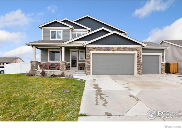 craftsman-style house with a front yard, a porch, an attached garage, and fence