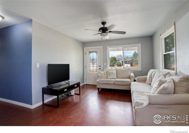 living room featuring a textured ceiling, dark hardwood / wood-style flooring, and ceiling fan