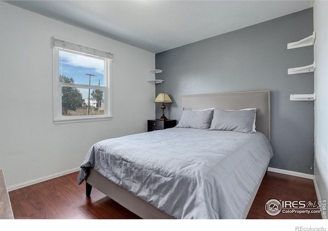 bedroom with dark hardwood / wood-style flooring