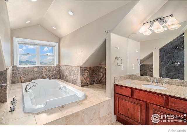 bathroom with vanity, tiled bath, and vaulted ceiling