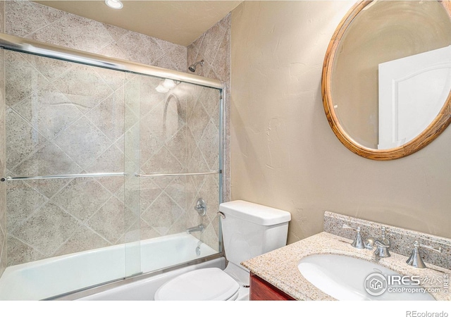 full bathroom featuring vanity, enclosed tub / shower combo, and toilet