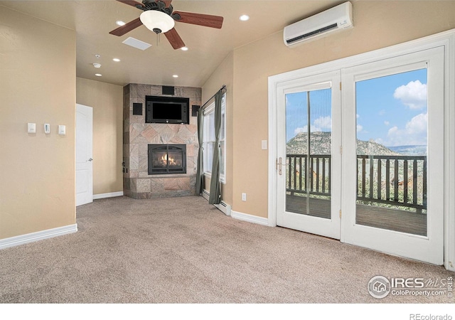 unfurnished living room with ceiling fan, a baseboard heating unit, a wall mounted air conditioner, a large fireplace, and light colored carpet