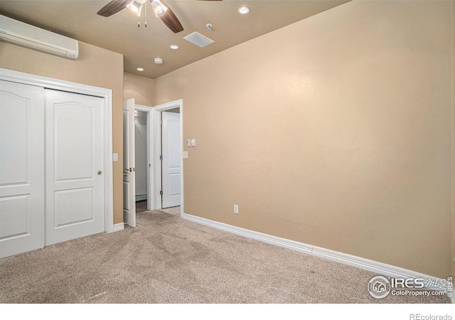 unfurnished bedroom featuring light carpet, a wall unit AC, a closet, and ceiling fan