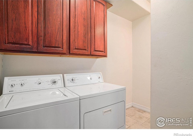 clothes washing area featuring cabinets and washer and dryer