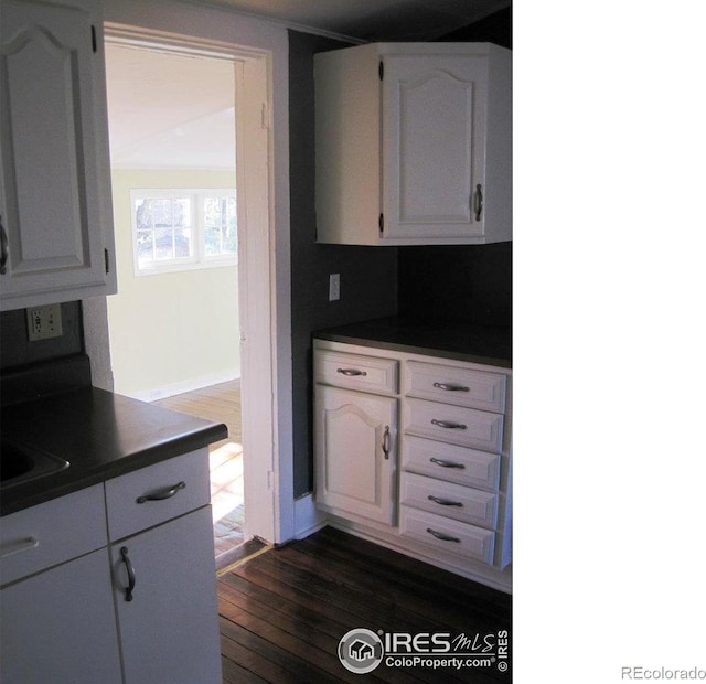 kitchen featuring dark hardwood / wood-style floors and white cabinetry